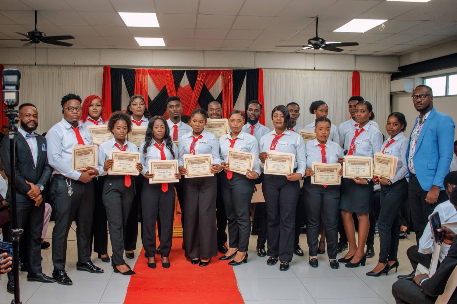 Remise des certificats Proleads : un groupe de diplômés en chemise blanche et cravate rouge tient son certificat